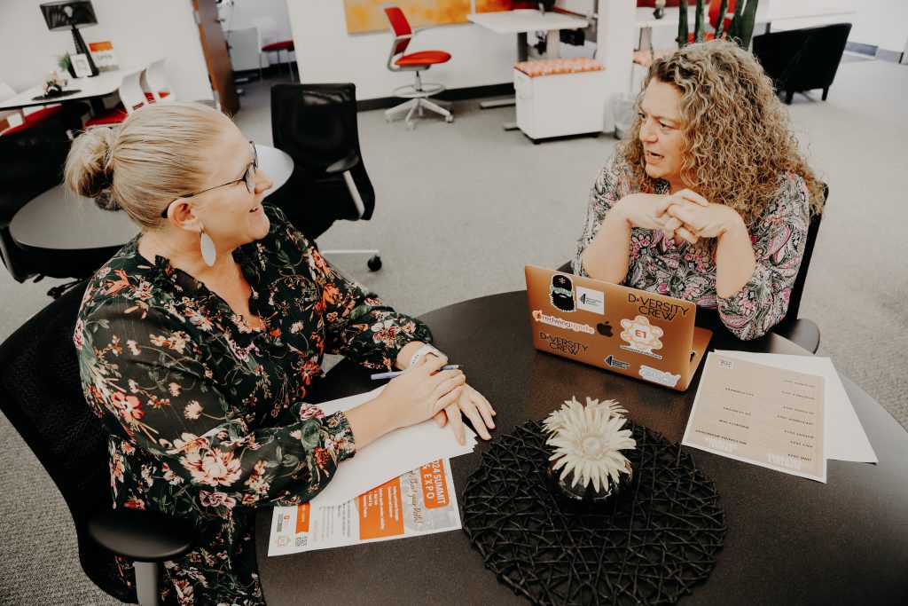 Two women sitting at a table engaging in a coaching session